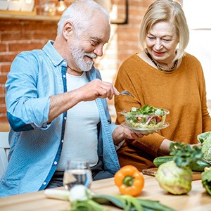 A cheerful senior couple making healthy salads to eat