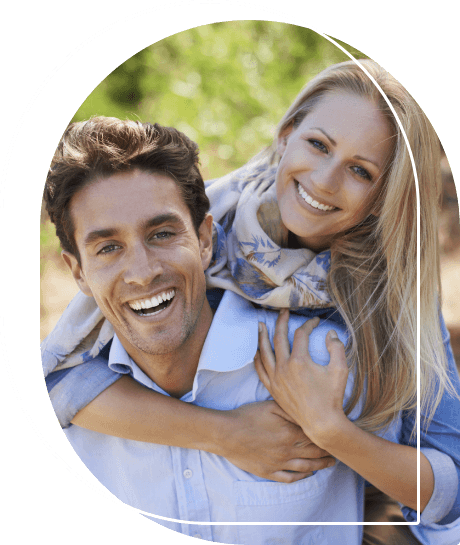 Man and woman smiling and hugging outdoors