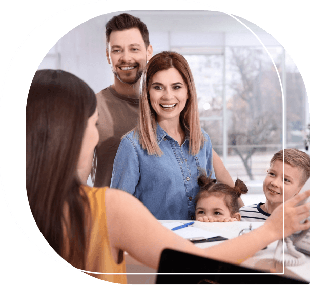 Family of four talking to dental office receptionist at front desk