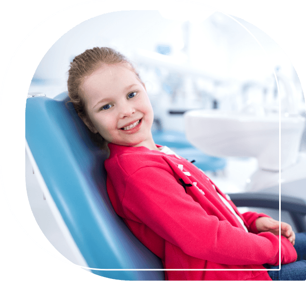 Child in red shirt smiling in dental chair