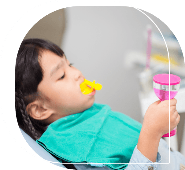 Child in dental chair having fluoride applied to their teeth