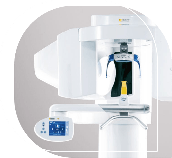 Large white C T cone beam scanner standing against wall