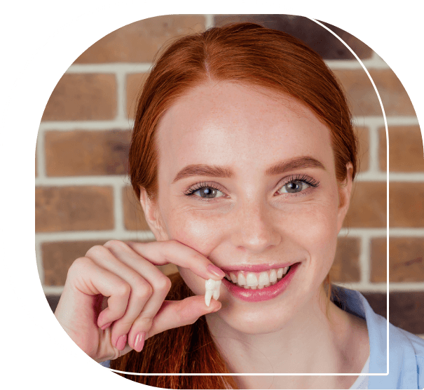 Woman smiling and holding an extracted tooth