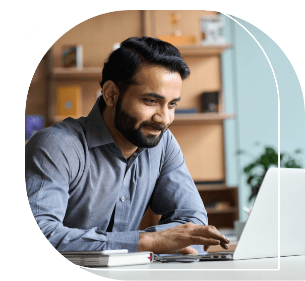 Man smiling while looking at his laptop