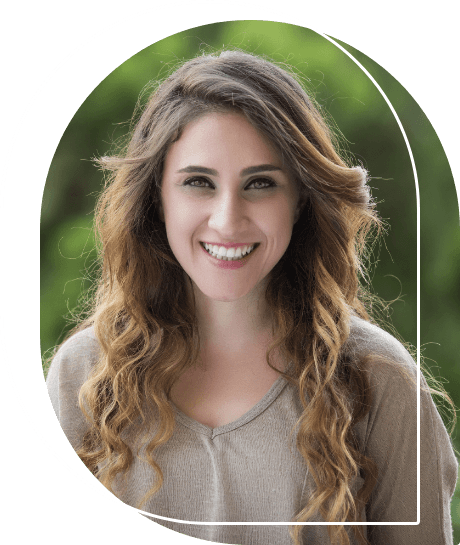 Woman with wavy brown hair smiling outdoors